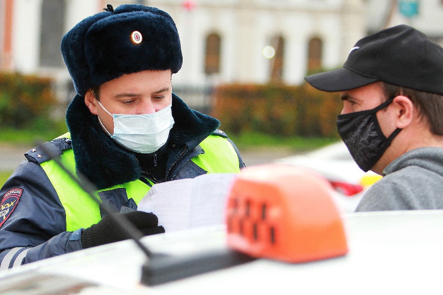 Инспектор ГИБДД Дмитрий Зонов проверяет документы у водителя такси Марата Ухдинова