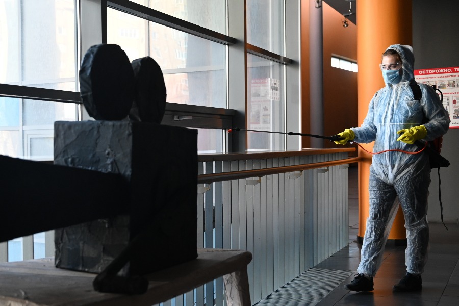 Доброволец из пожарной команды «Спасение ПРО» Ольга Самсонова дезинфицирует экспонат — кинокамеру в фойе Учебно-театрального комплекса ГИТИС, расположенного в Юго-Западном административном округе