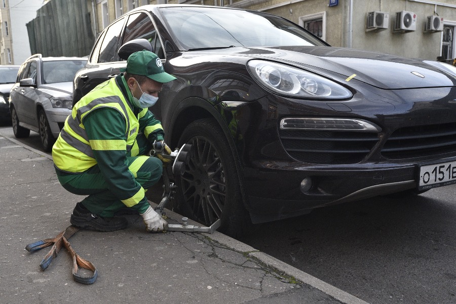 Сотрудник Моспаркинга Андрей Аронин готовит «Порше» к транспортировке