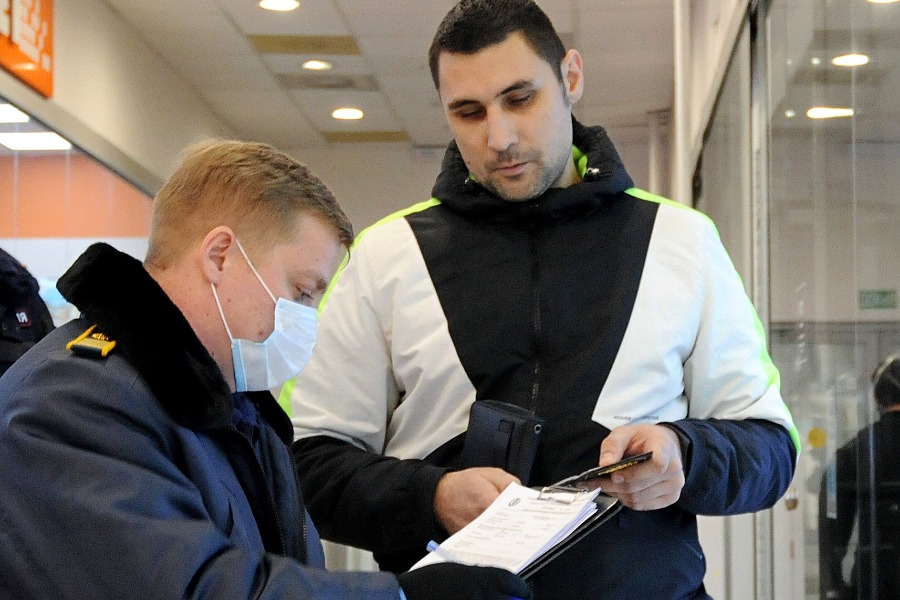 Главный инспектор ОАТИ Антон Камнев составляет протокол на нарушителя — посетителя торгового центра Алексея Жамалова