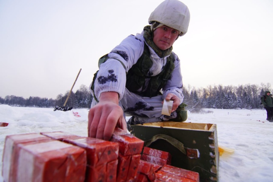 Гвардии капитан Эльгар Бадаев укладывает толовые шашки для подрыва льда