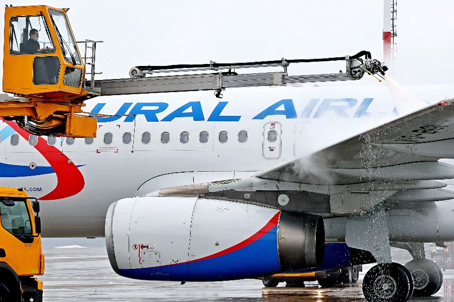 Оператор-деайсер Константин Гуртовой (в кабине машины) обрабатывает самолет противообледенительным составом в аэропорту Домодедово. После такой процедуры снег и наледь не налипнут на корпус воздушного судна, и полет будет безопасным