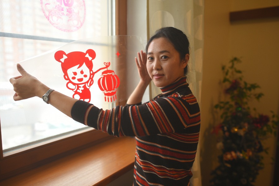 Кан Цзюань украшает квартиру к встрече Нового года по китайскому календарю. Главный цвет украшений по традиции — красный