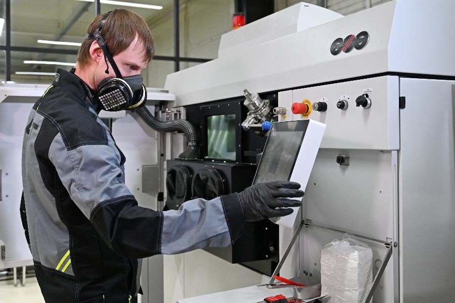 Оператор первого цеха Дмитрий Голубин программирует 3D-принтер на создание элементов нового авиационного двигателя. Лучи лазерных установок аппарата будут одновременно выплавлять сразу несколько деталей разной конфигурации