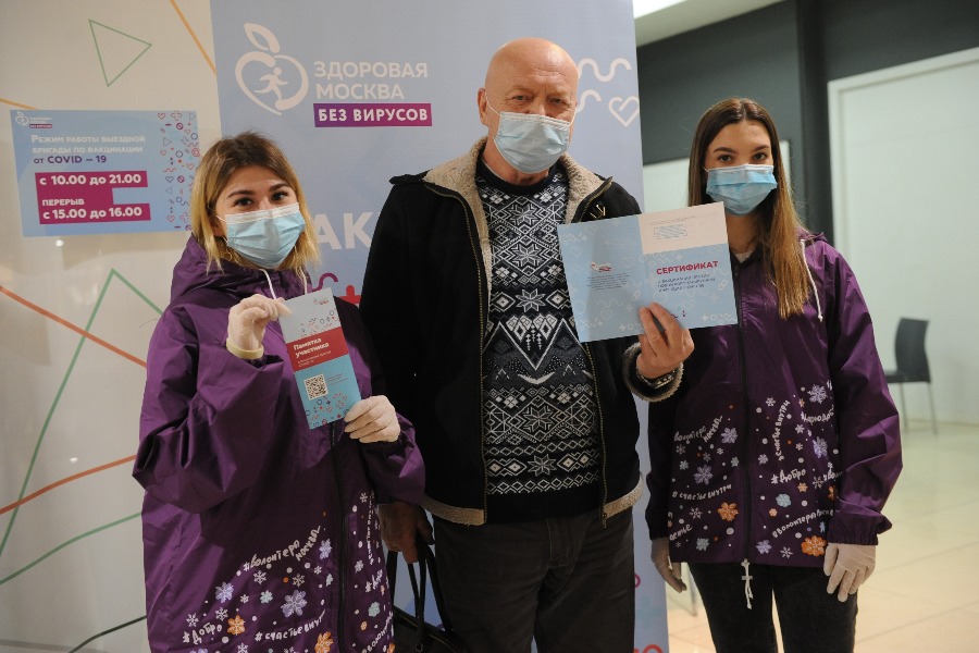 Студентки-волонтеры Алина Кузнецова (слева) и Анжелика Бабаджан с москвичом Владимиром Земцевым