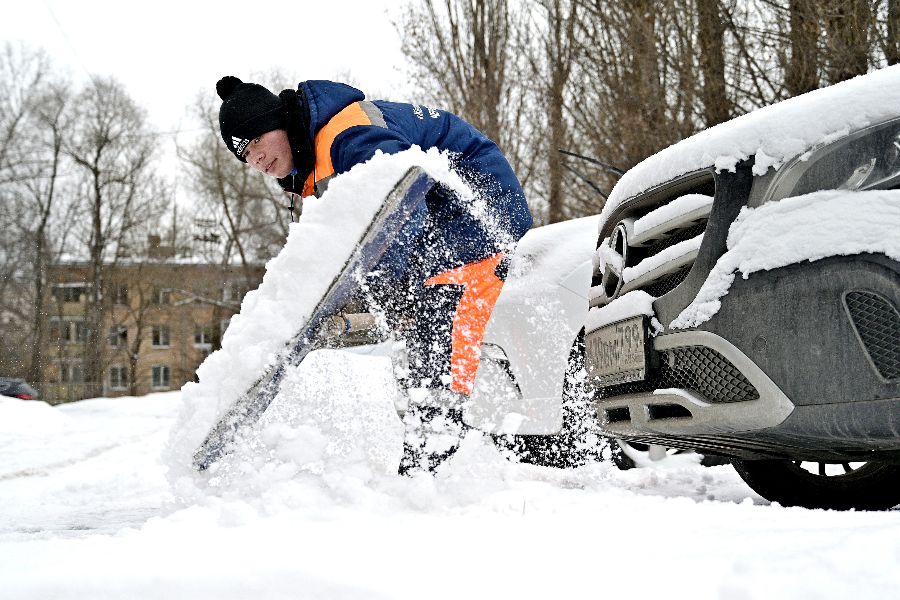 Сотрудник ГБУ «Жилищник» Отабек Илибоев расчищает парковку у станции метро «Профсоюзная»