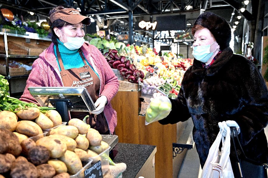 Продавец Галина Морозова предлага- ет выбрать постоянной покупательнице ярмарки на Профсоюзной улице свежие овощи и зелень