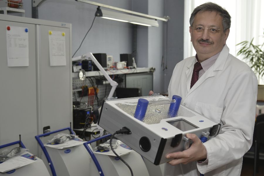 Генеральный директор московской компании Яков Гольдштейн держит в руках установку для обеззараживания воздуха с ультрафиолетом сплошного спектра, которую производит и поставляет за рубеж их предприятие