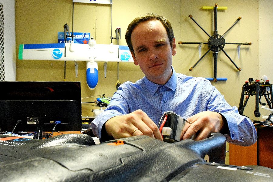 Организатор олимпиады Кружкового движения Национальной технической инициативы Дмитрий Сурков меняет аккумулятор в беспилотнике