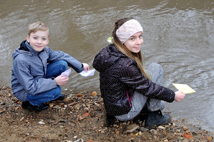 Гоша и Варя Чевыкаловы пускают самодельные бумажные кораблики по реке Котловка в Москве — этой игре их научила мама Ирина
