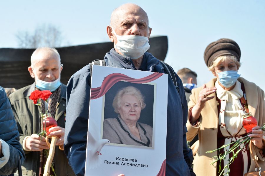 Участник акции Михаил Карасев (на переднем плане) пришел на Поклонную гору, чтобы почтить память узников фашистских концлагерей. Он принес портрет своей родственницы Галины Карасевой, которая ребенком стала пленницей немцев и своими глазами видела ужасы, творившиеся в концлагере