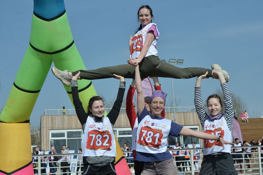 Участницы команды чирлидинга МГУ имени М. В. Ломоносова Кристина Комкова, Юлия Шубина, Мария Аксенова, Елизавета Таирова (слева направо) и Анна Куманова (сверху) разминаются перед стартом. Им предстоит пройти дистанцию с препятствиями