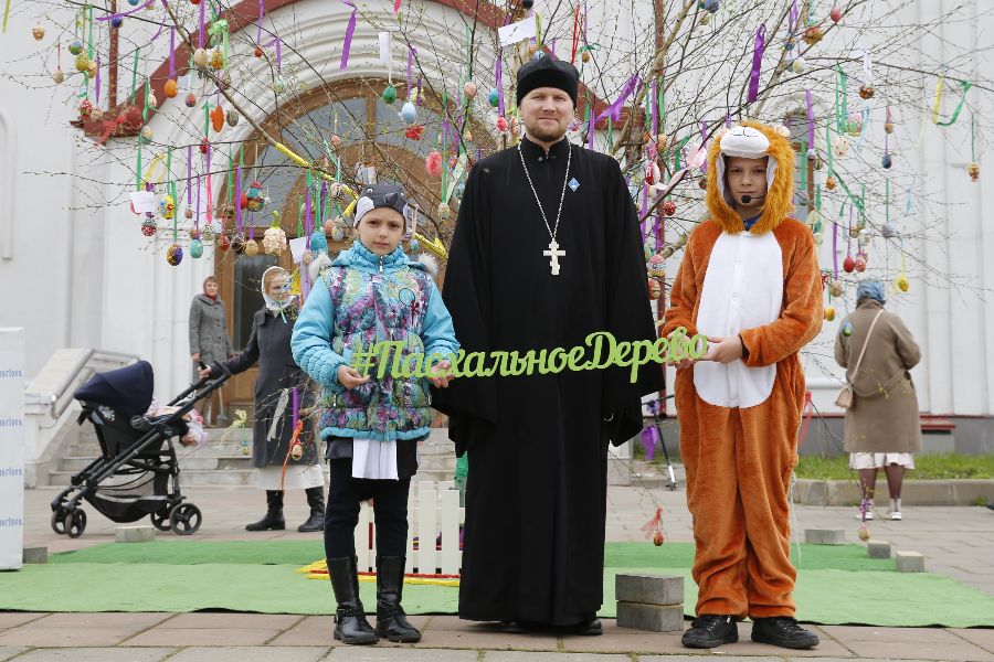 Организатор акции «Пасхальное дерево» иерей храма Казанской иконы Божией Матери в Орлово Максим Галкин с победителями конкурса Настей и Димой Теленковыми. Дети смастерили самое большое яйцо. В прошлом году ребята тоже заняли первое место и получили подарки