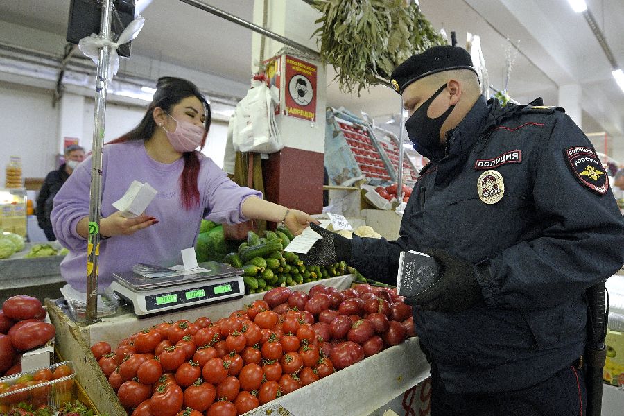 Сотрудник патрульно-постовой службы УВД по Северо-Восточному округу Москвы Иван Гришаев проверяет документы у продавца рынка Каринэ Умаровой
