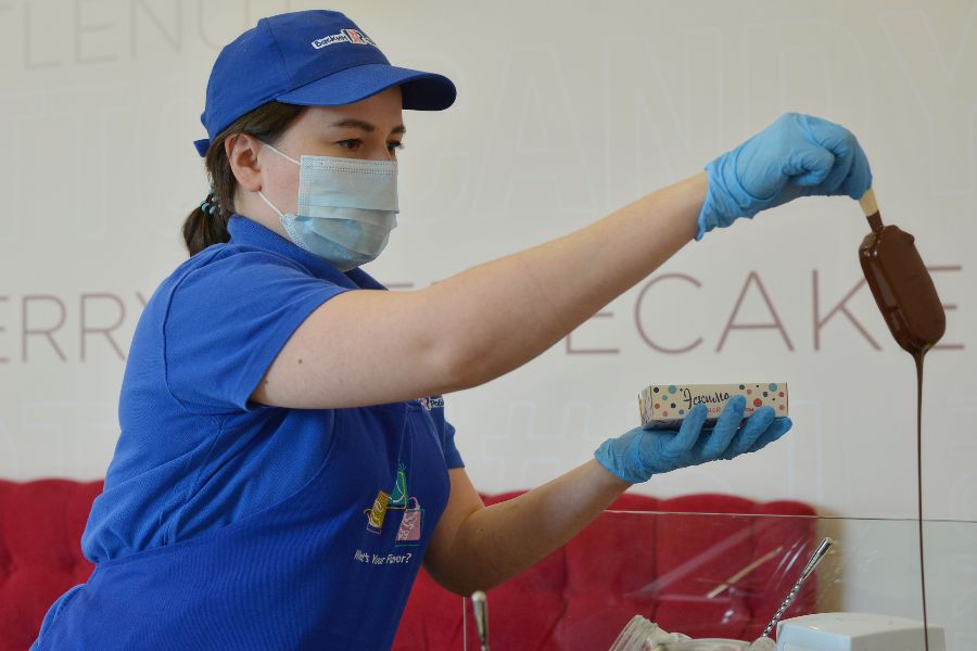 Сотрудник одной из крупнейших фабрик мороженого Анна Салихова обмакивает будущее эскимо в молочный шоколад. Такое сочетание — одно из любимых у московских покупателей, хотя компании предлагают сотни видов холодного лакомства