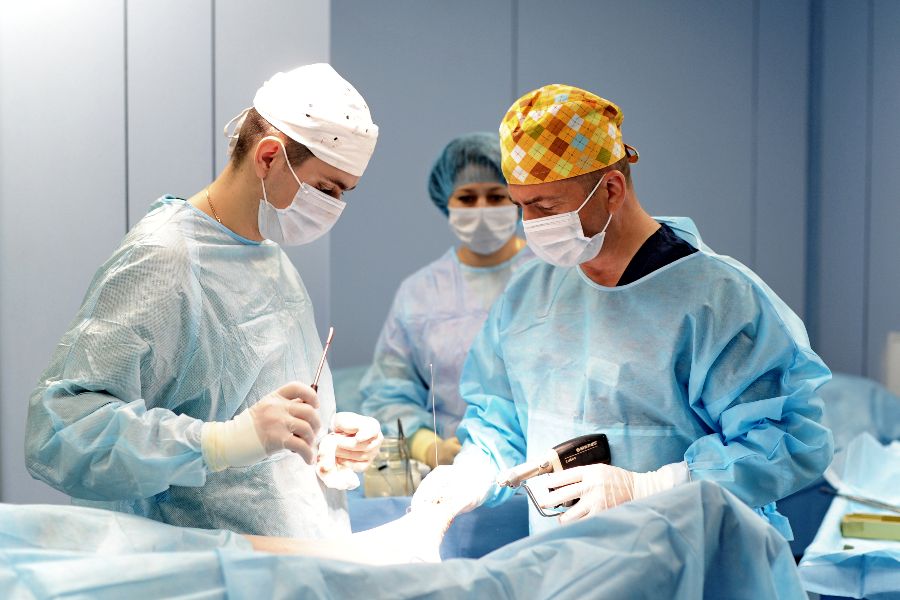 Начальник отделения неотложной травматологии Артур Керимов (справа) проводит операцию. Ему помогают старший ординатор Игорь Хоминец и операционная сестра Марина Крылова