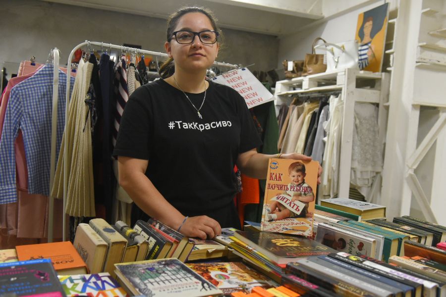 Администратор экоцентра «Сборка» Яна Краснова показывает гостям музея вещи, которые принесли москвичи для дальнейшей переработки. Кстати, посетители, которые придерживаются концепции осознанного потребления, могут купить книги или одежду, которые были сданы в пункт приема