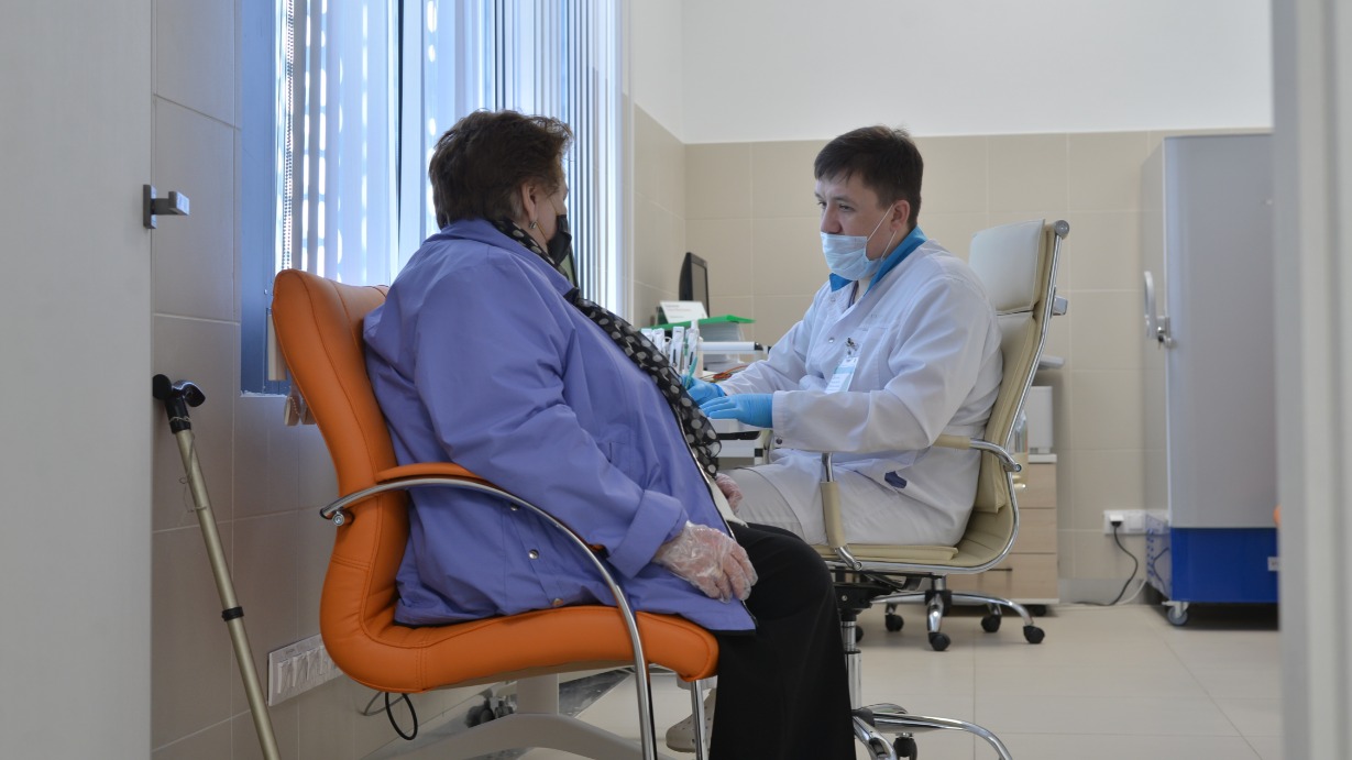 Сотрудник прививочного пункта в ТРЦ «Щелковский» Демьян Егольников опрашивает москвичку Светлану Аванесьянц перед вакцинацией