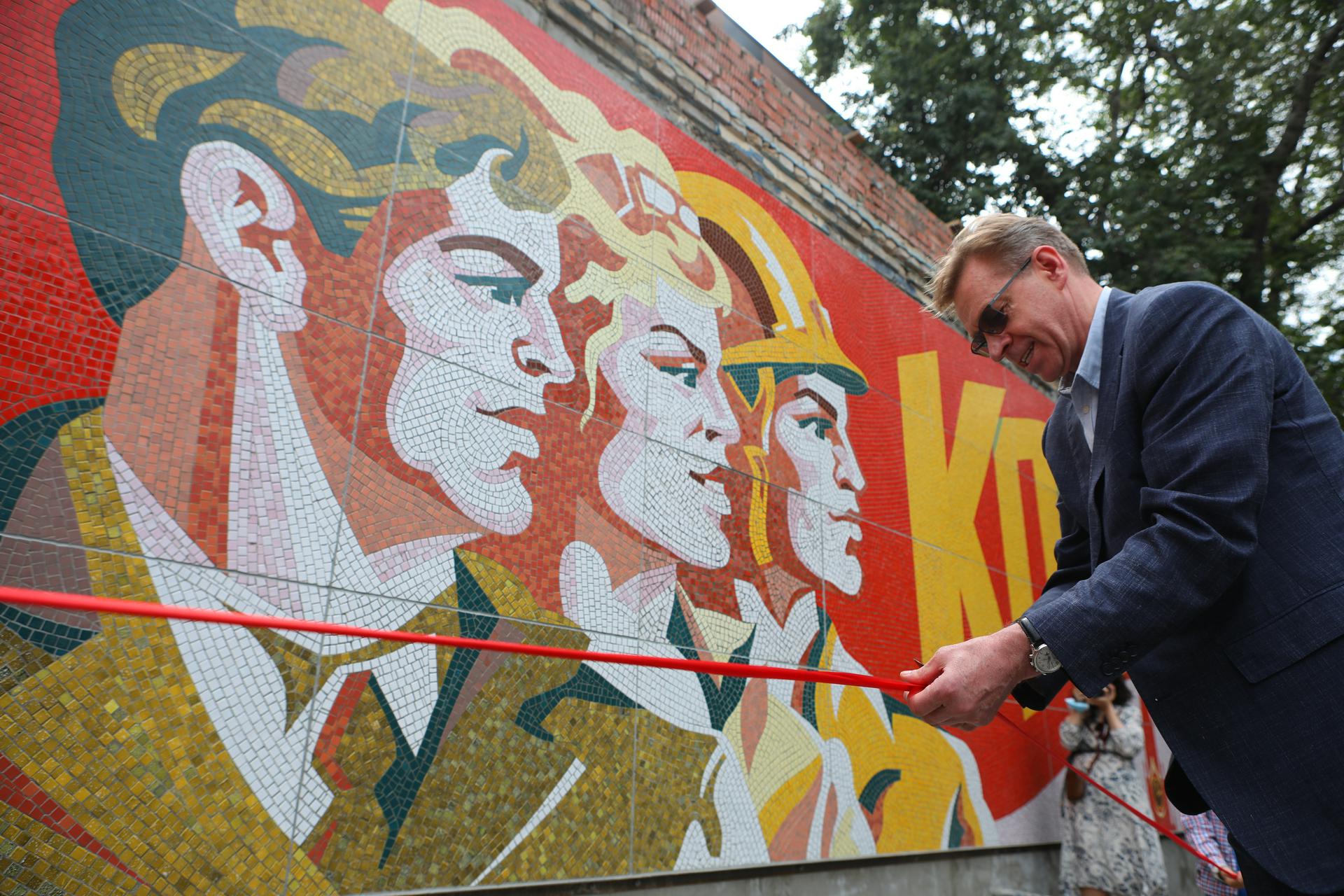 Генеральный директор Московского электродного завода Сергей Юрков перерезает символическую ленточку на открытии восстановленного мозаичного панно