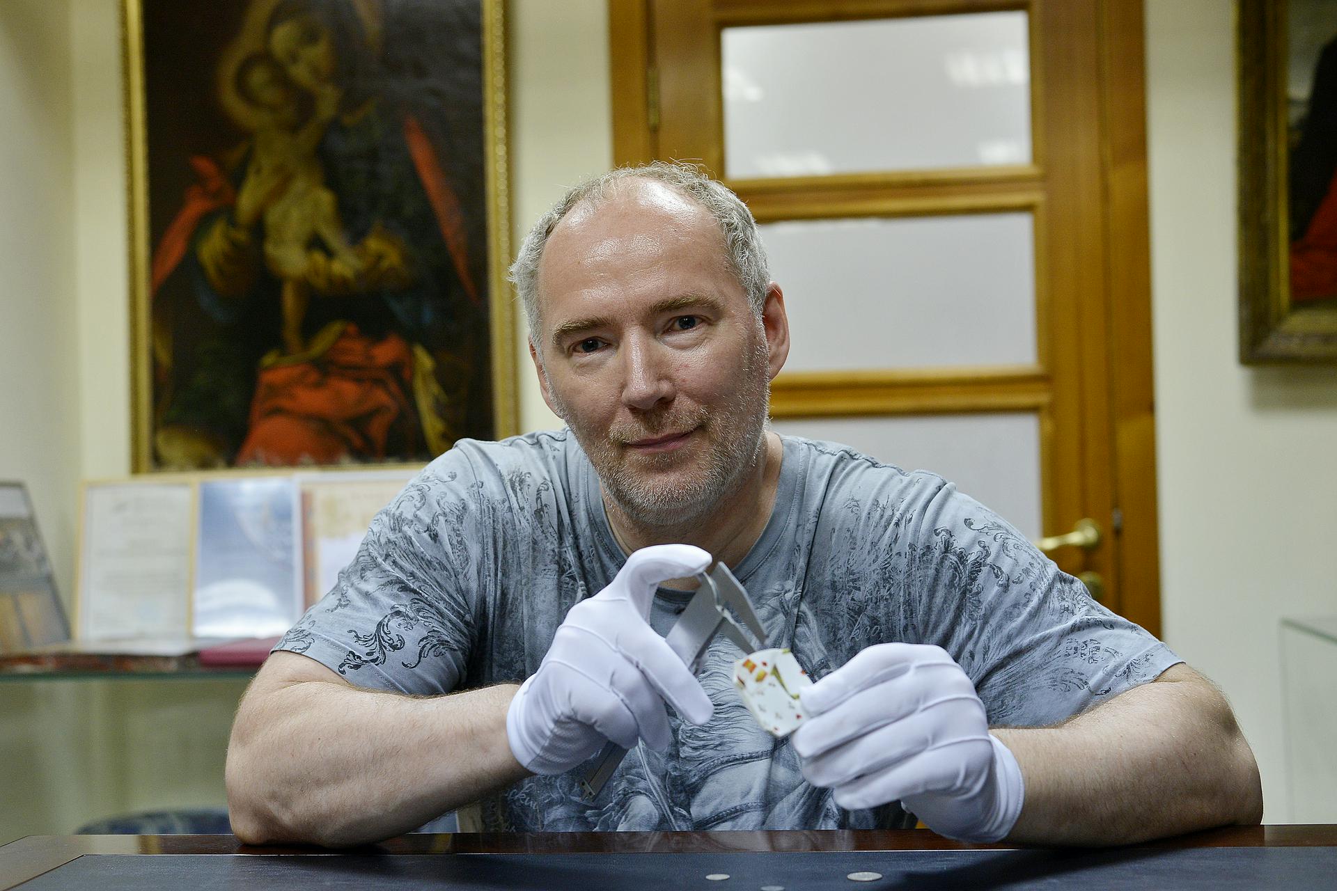 Гендиректор «Столичного археологического бюро» Константин Воронин показывает найденный фрагмент фарфорового блюдца XIX века и монеты этого периода