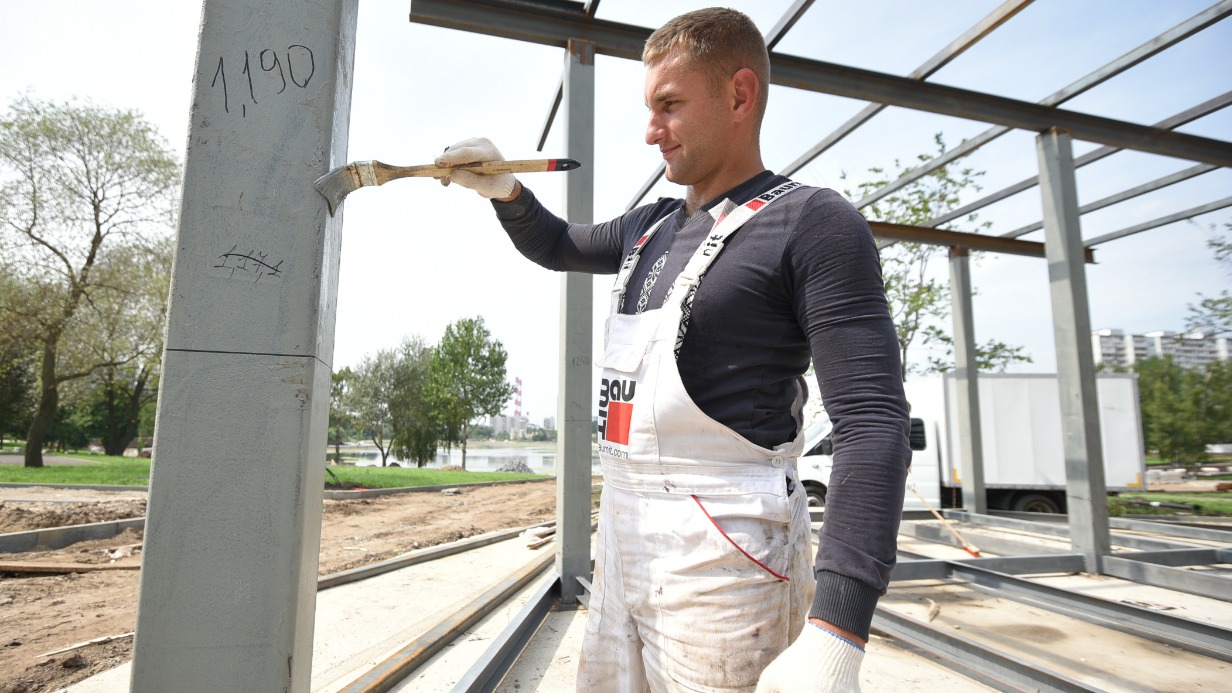 Строитель Евгений Николайчук устанавливает опорную конструкцию для будущего павильона на территории Гольяновского парка