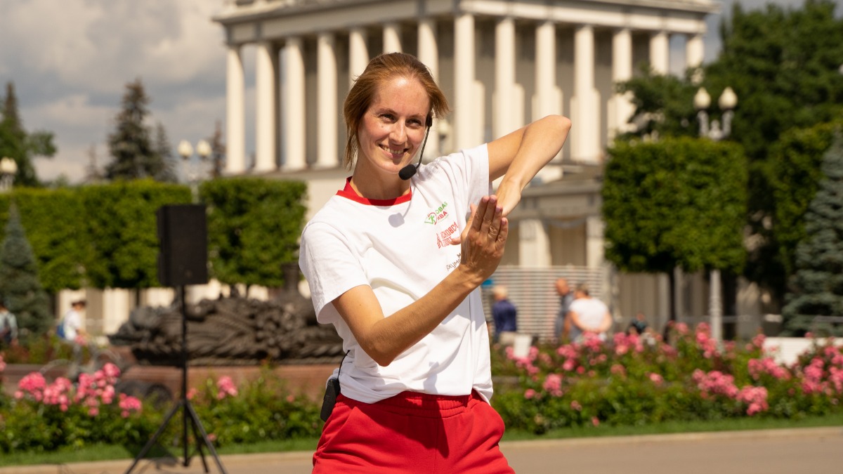 Тренер Кира Беляева провела мастер-класс по хореографии в рамках празднования Дня физкультурника на ВДНХ. Она научила москвичей основным танцевальным движениям. Занятие прошло на площадке около фонтана «Каменный цветок»