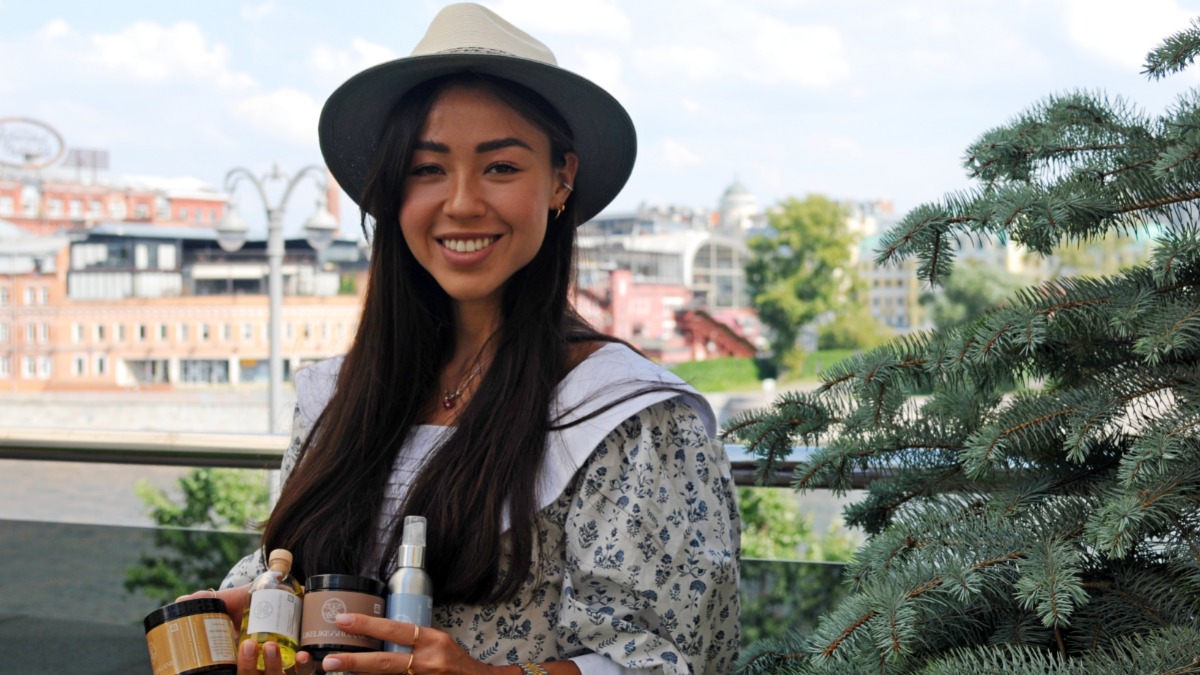 Руководитель бренда органической косметики София Платонова держит в руках продукцию своей компании, которую можно купить в дьюти-фри на стенде Made in Moscow