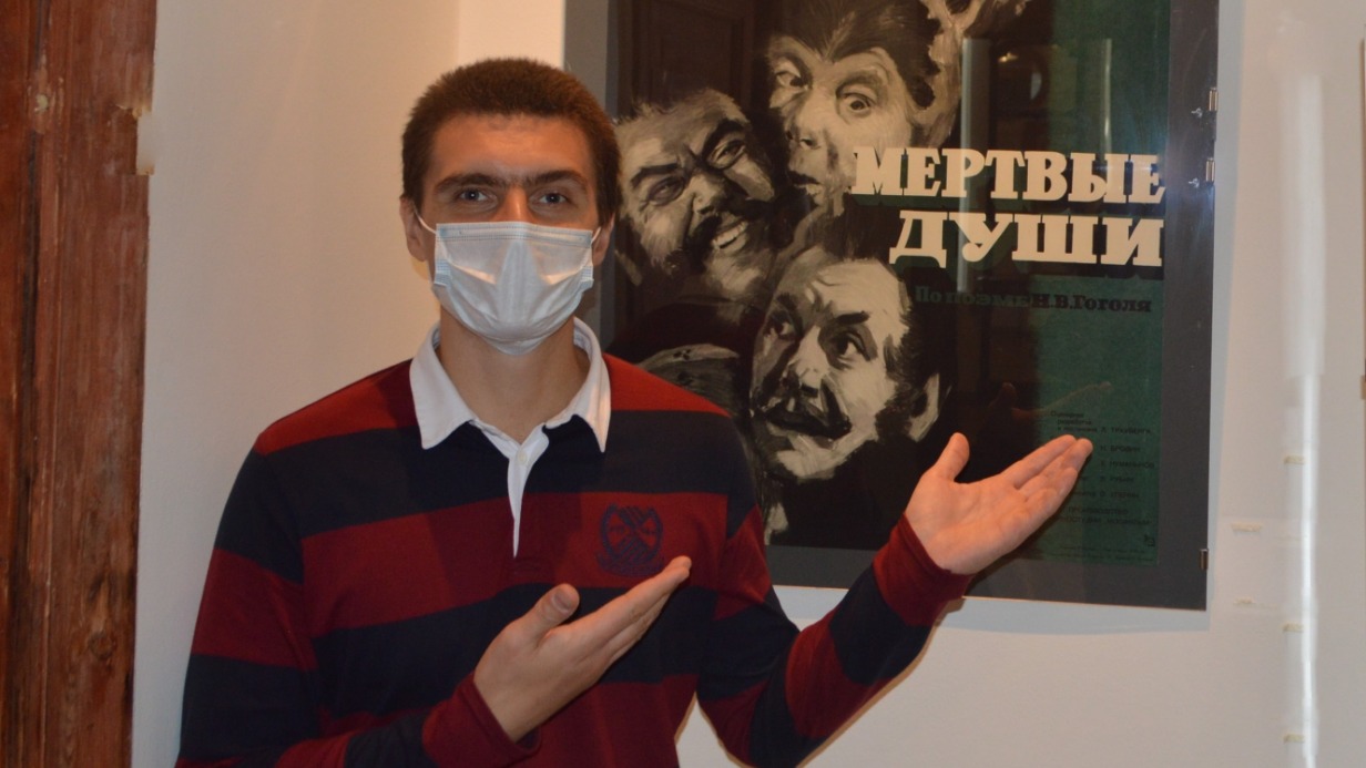 Сотрудник музея Иван Назаров на фоне афиши кинокартины по инсценировке Булгакова «Мертвые души»