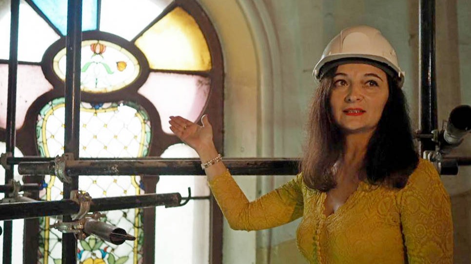 Руководитель проектной мастерской Алена Казарова показывает витраж, который скоро отправят на реставрацию