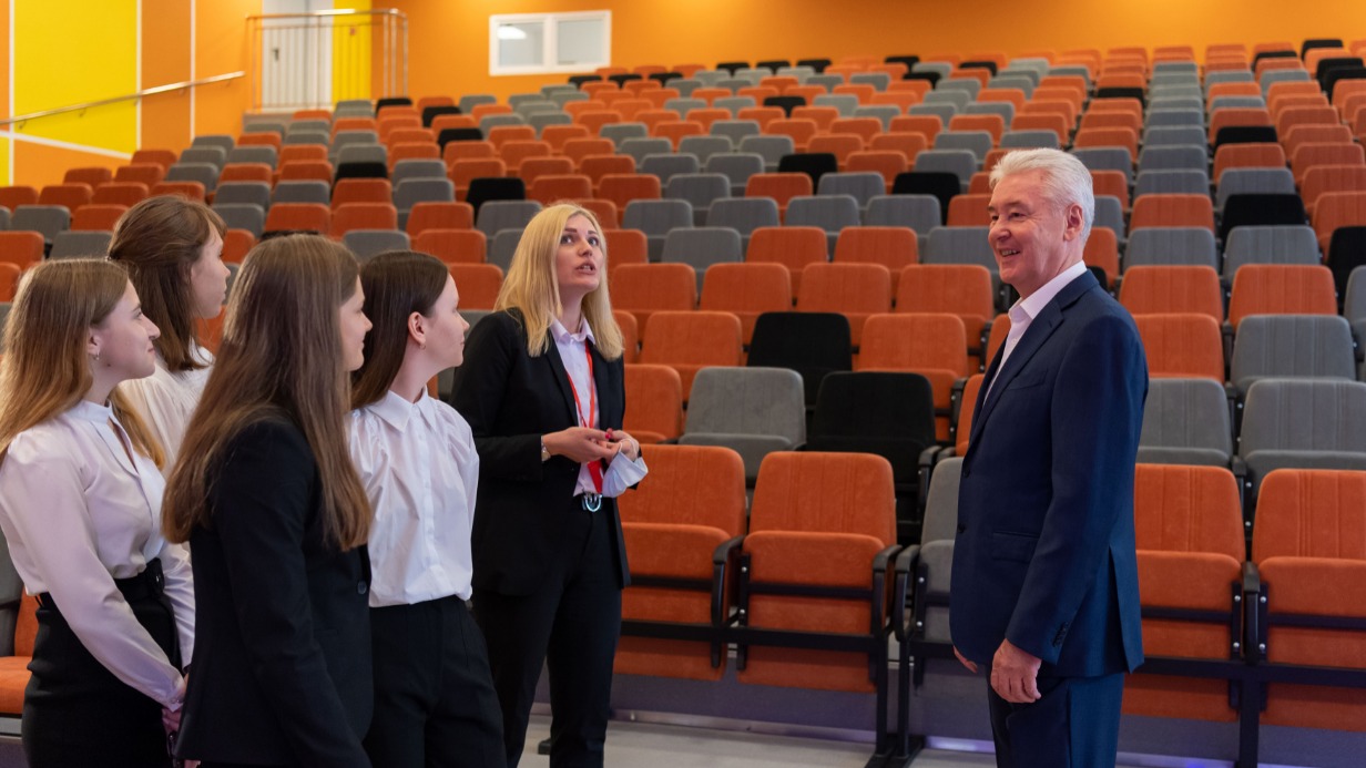 Мэр Москвы Сергей Собянин (справа), директор школы № 338 имени Героя Советского Союза А. Ф. Авдеева Мария Андрианова и старшеклассники учебного заведения осмотрели актовый зал нового школьного корпуса