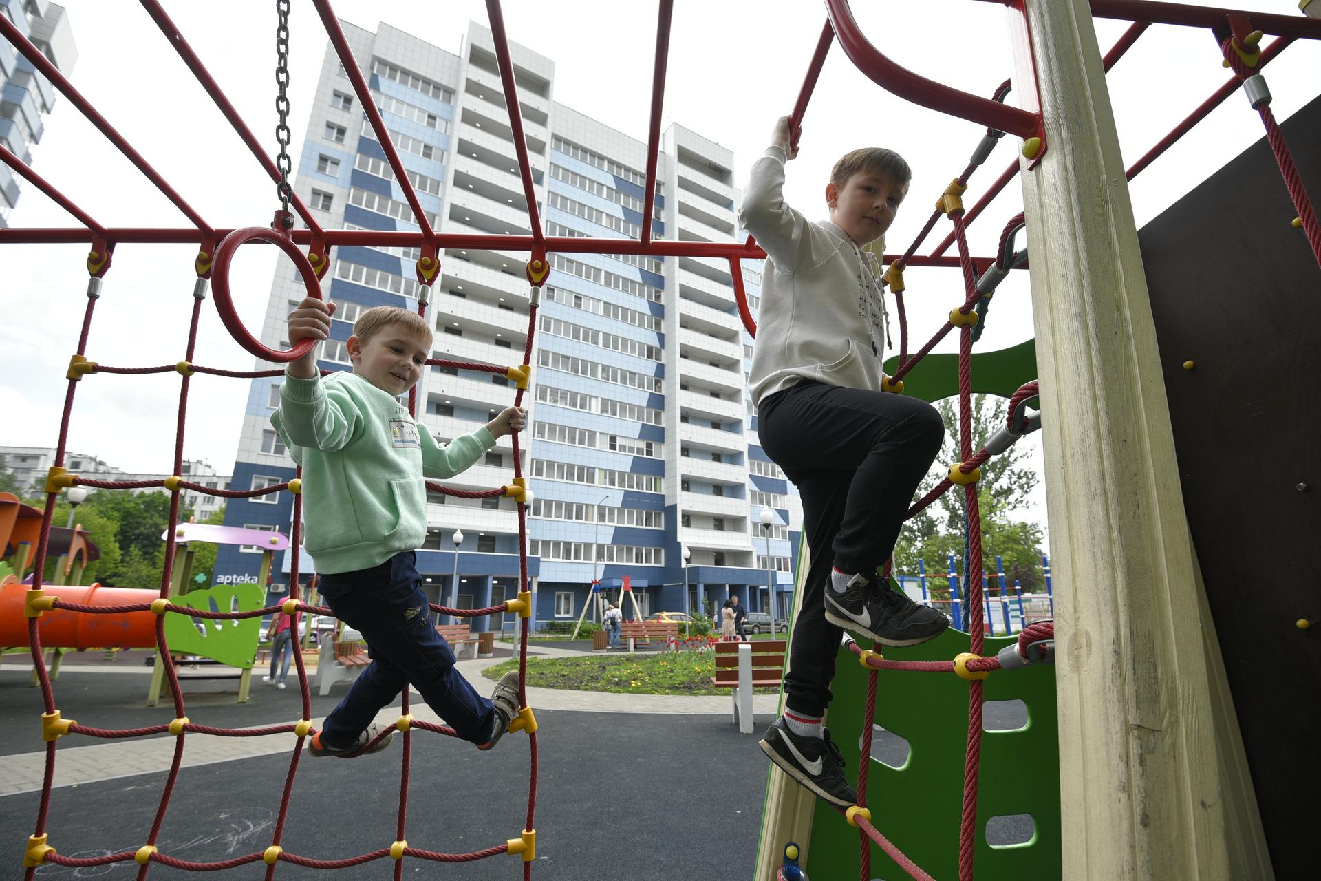 Братья Никита (слева) и Ярослав Азаровы играют на детской площадке возле нового дома на Судостроительной улице, куда переехали жители ближайших пятиэтажек