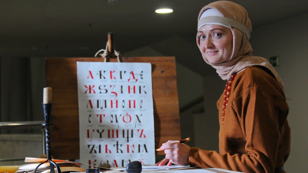 Анастасия Никонова проводит для москвичей мастер-класс по древнерусской каллиграфии в рамках фестиваля к 800-летию великого князя Александра Невского. Девушка пишет какое-нибудь слово или имя участника занятия, а ее ученики пытаются в точности скопировать каждую букву