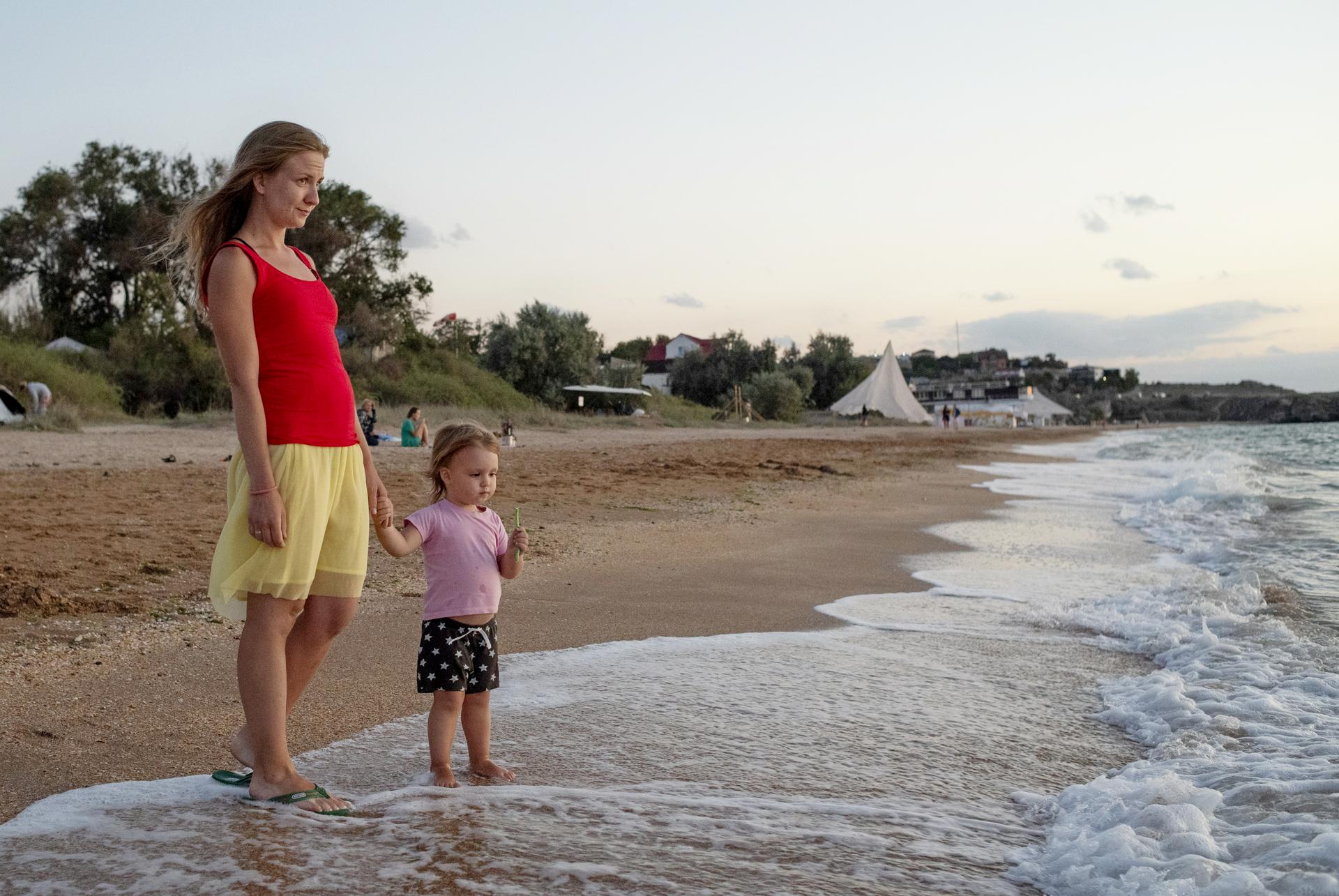 Крым, город Щелкино. Туристка Ольга Микулик и ее дочь Ева отдыхают на берегу Азовского моря