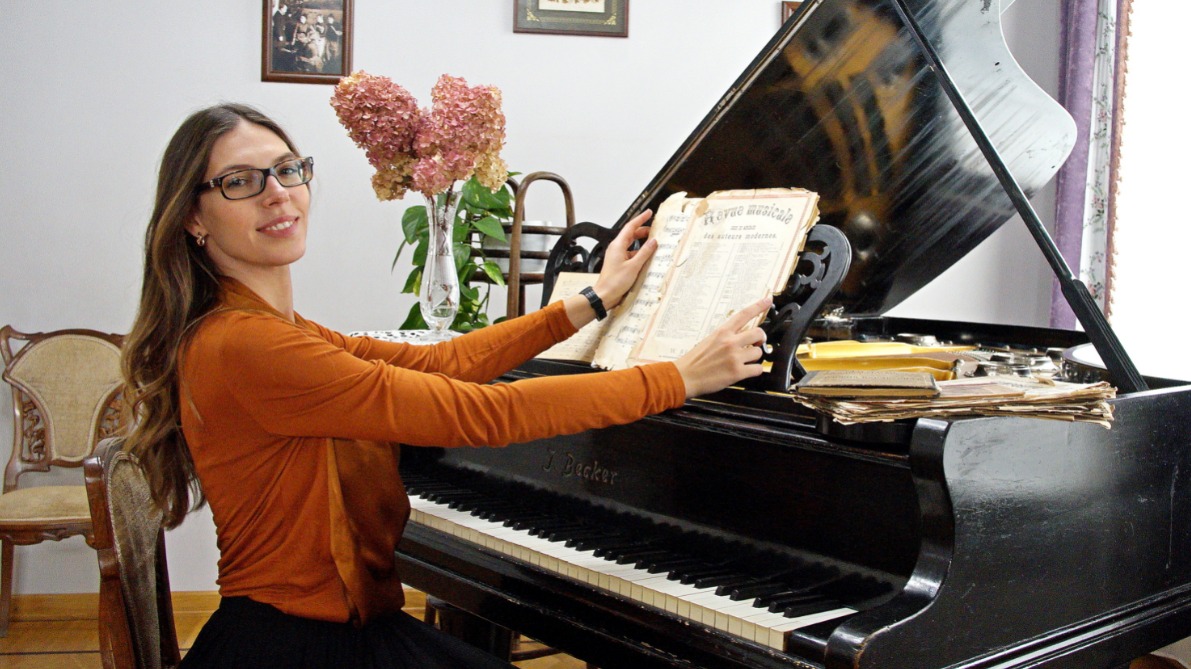 Сотрудница дома-музея Анастасия Буковская ставит старинные ноты на отреставрированный рояль прошлого столетия