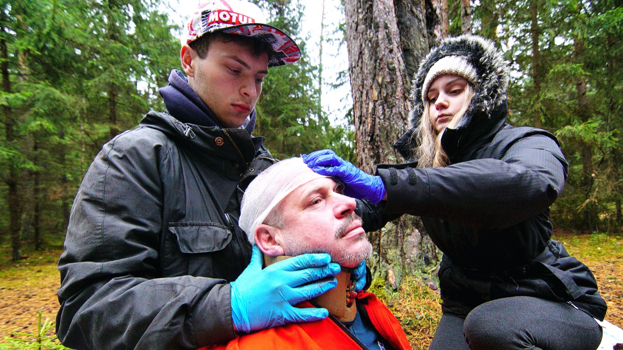 Участники учебно-тренировочного дня Александр Рублев (слева) и Диана Йоргова оказывают первую помощь Александру Губанову, который изображает человека с травмой головы, переломами руки и ноги