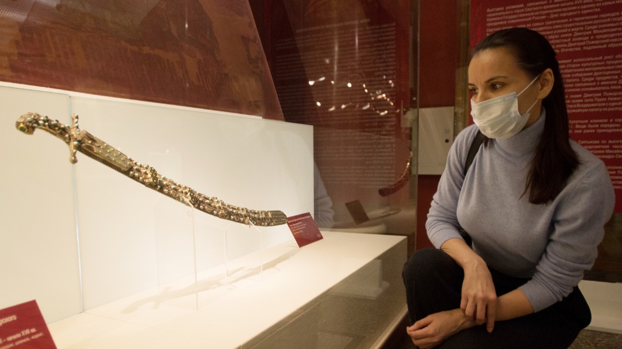 Москвичка Анна Куликова рассматривает парадную саблю князя Дмитрия Пожарского. Эта ценная реликвия — один из экспонатов новой выставки, которая открылась в Государственном историческом музее