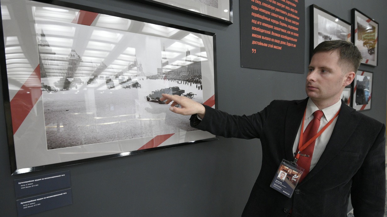 Экскурсовод Музея Победы Дмитрий Аксенов проводит экскурсии по выставке, посвященной параду 1941 года. На архивных кадрах запечатлены представители власти СССР, солдаты, идущие ровным строем по Красной площади, военная техника