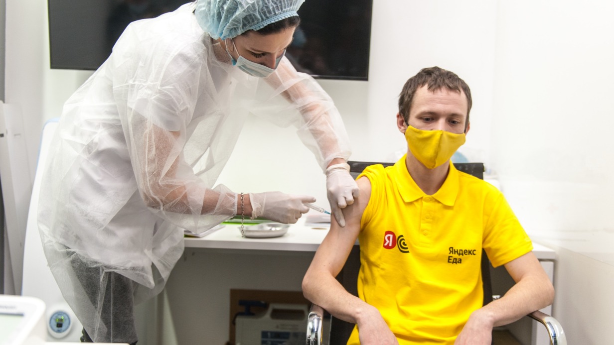 Медсестра Евгения Горяинова делает прививку от коронавируса курьеру Андрею Митронину