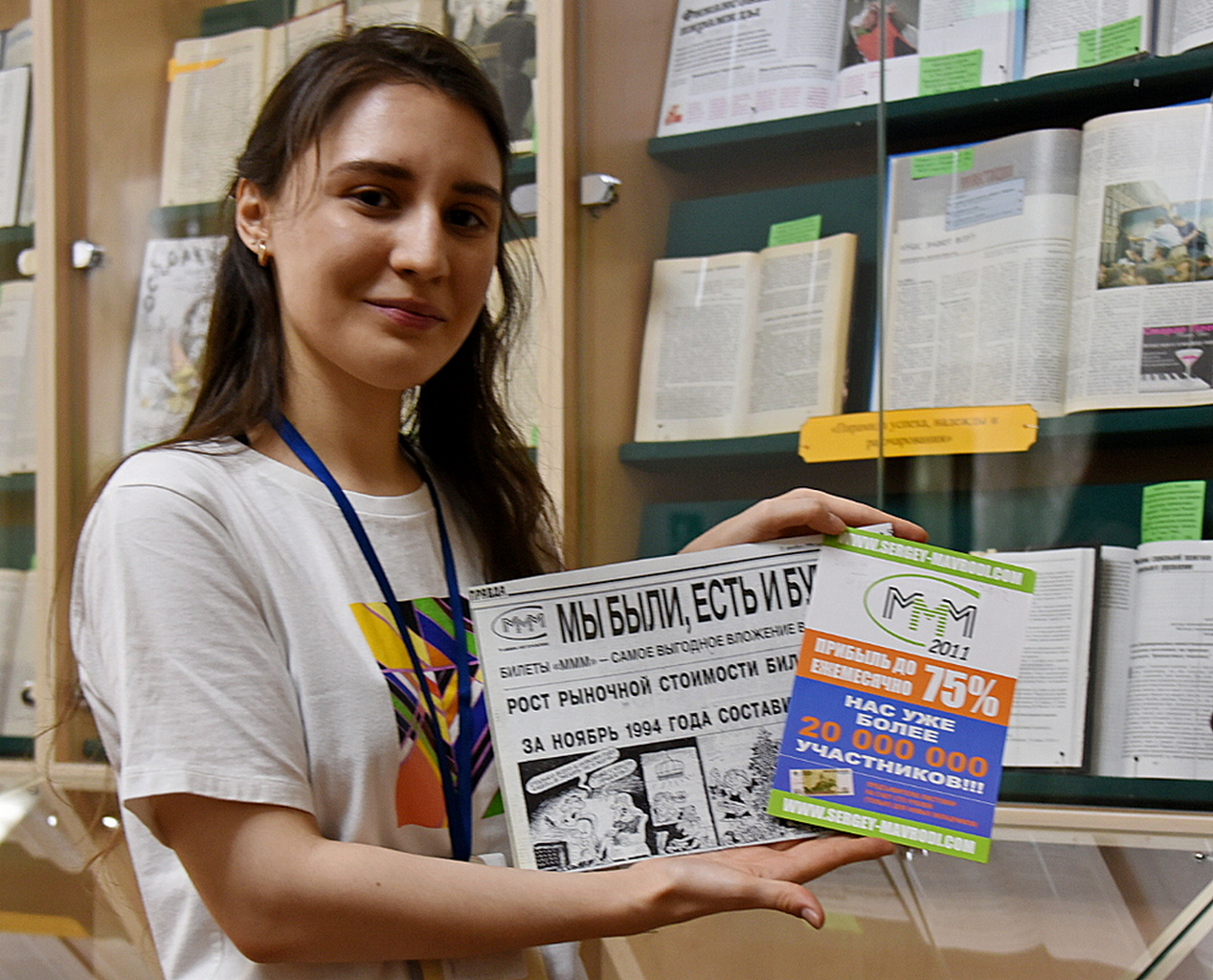 Куратор выставки «Истории обмана» Анастасия Кенберова показывает экспонаты — рекламу финансовой пирамиды «МММ»