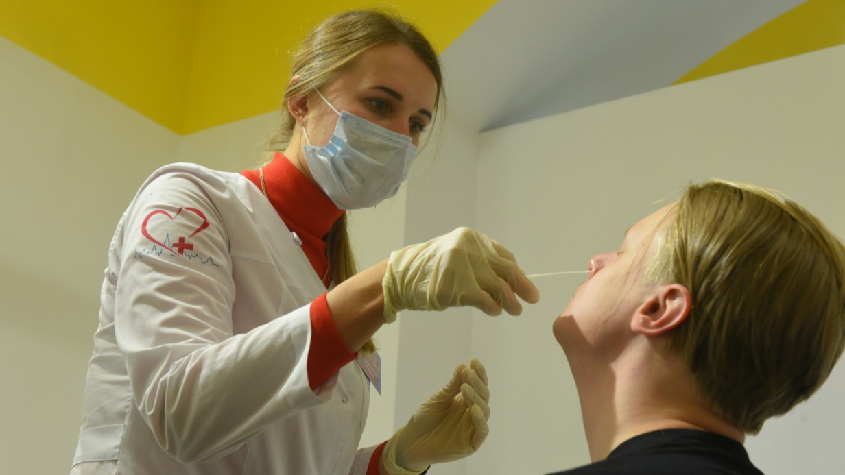 Медсестра Анна Курицына берет мазок у москвича Всеволода Малинина для экспресс-тестирования на ковид