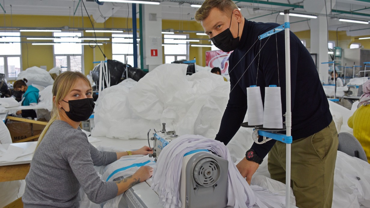 Исполнительный директор столичного промпредприятия Сергей Ярошевич и швея Ирина Золотухина на производстве обсуждают процесс создания костюмов, которые используются для защиты врачей в «красных» зонах больниц, в которых лечат пациентов с коронавирусом