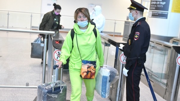 Сотрудник полиции и прилетевшие из ЮАР пассажиры в международном аэропорту Домодедово имени М. В. Ломоносова