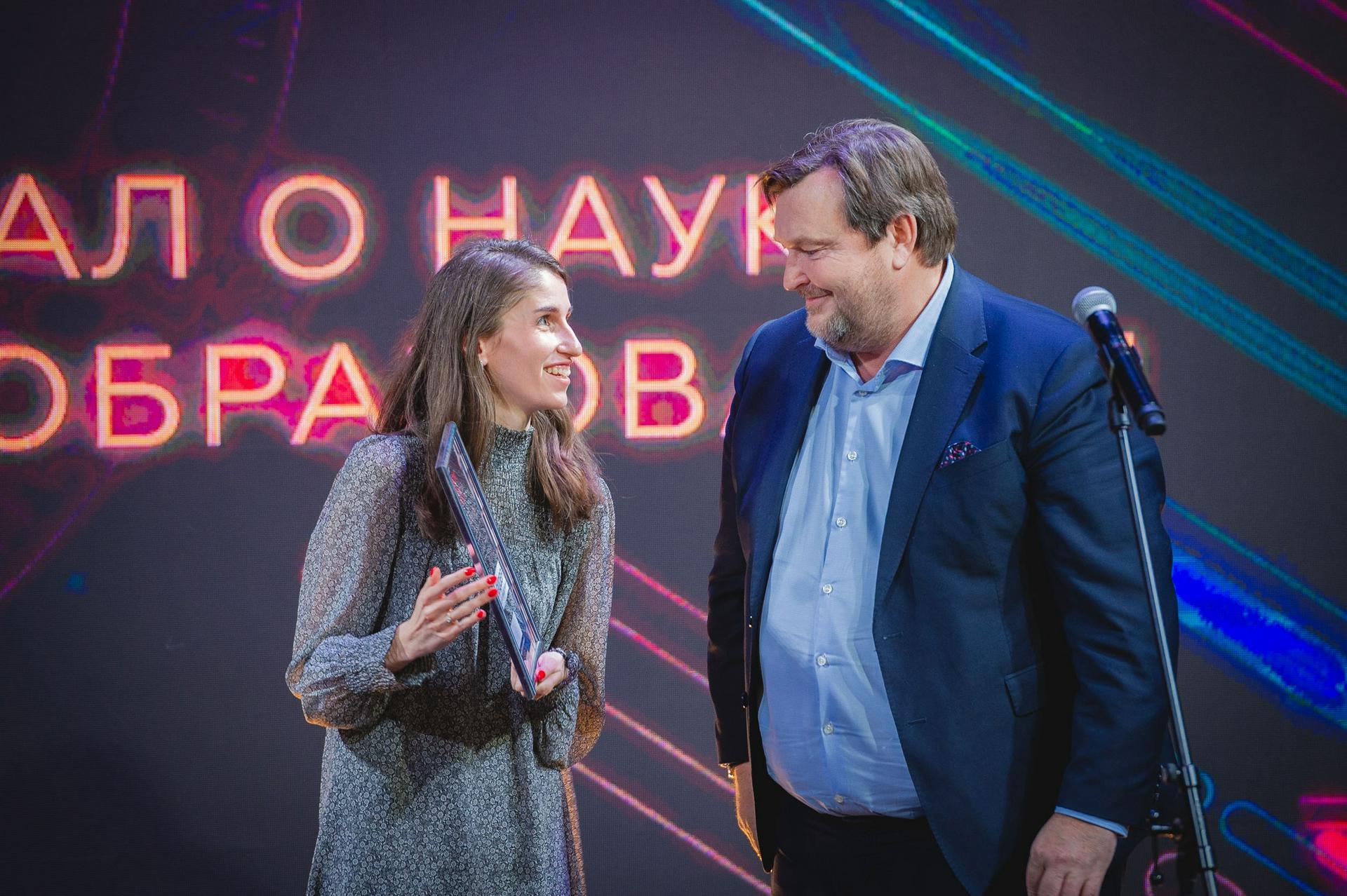 Директор Департамента международного сотрудничества и связей с общественностью Минпросвещения России Сергей Шатунов вручает награду специальному корреспонденту Марьяне Шевцовой