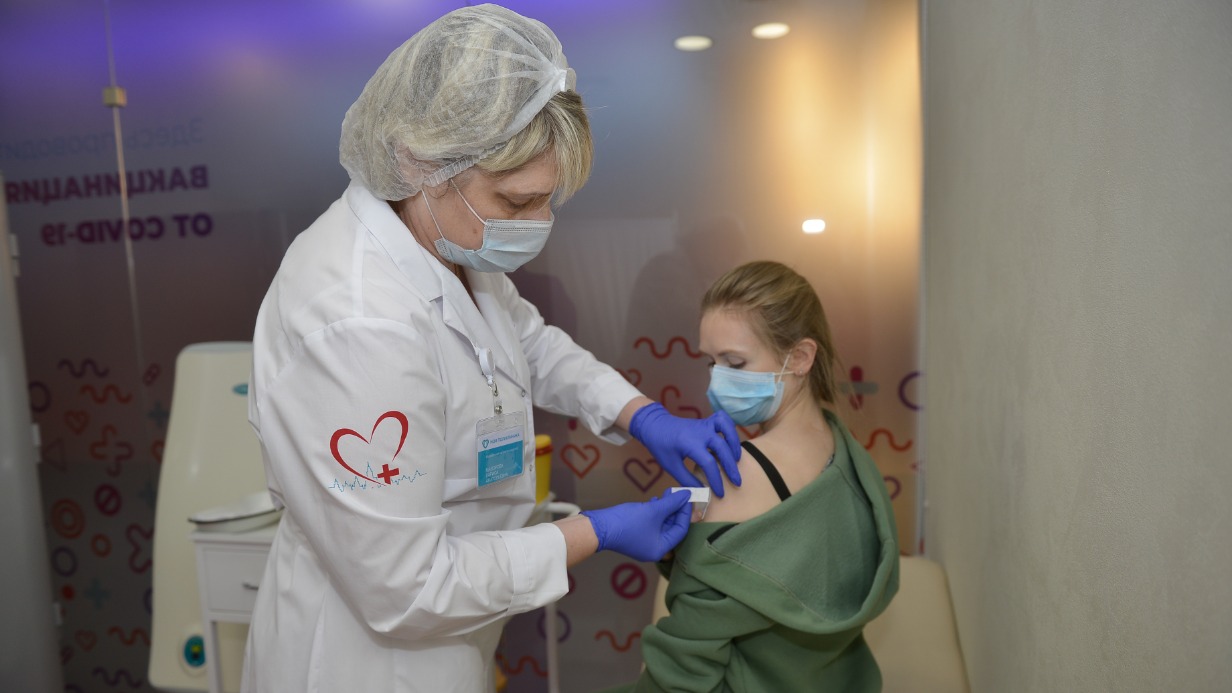 Медсестра Лариса Майорова делает прививку против ковида жительнице столицы Полине Ферисиде