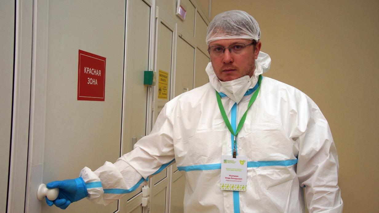 Медицинский психолог Игорь Мартынов позирует фотографу перед входом в «красную» зону в резервном госпитале «Крылатское». Через несколько минут он наденет защитную маску и отправится на смену