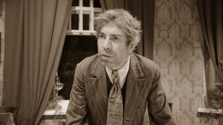 Кадр из фильма Владимира Бортко «Собачье сердце» (1988). Главный герой — Полиграф Шариков (Владимир Толоконников), квазичеловек, по cюжету созданный ученым из дворового пса, которому пересадили гипофиз и семенники маргинала Клима Чугункина. Полноценным членом общества Шариков не стал, зато принес много проблем окружающим