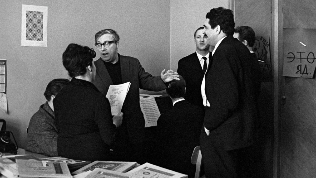 Поэт Лев Ошанин (второй слева) читает стихи на собрании