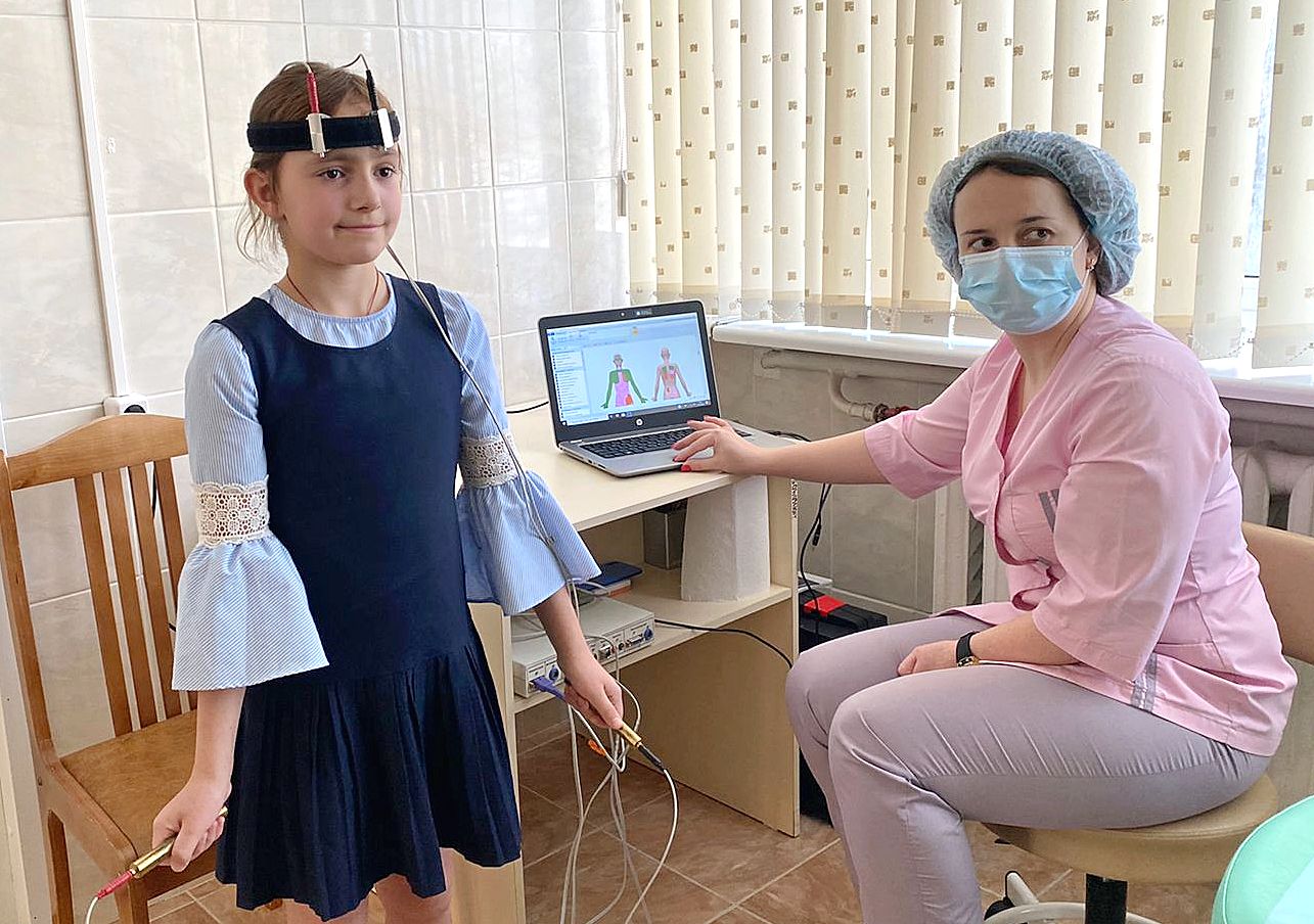 Медицинская сестра по физиотерапии Мария Снисарь проводит анализ организма школьницы Елизаветы Зубкевич на медсканере «БИОРС-05»