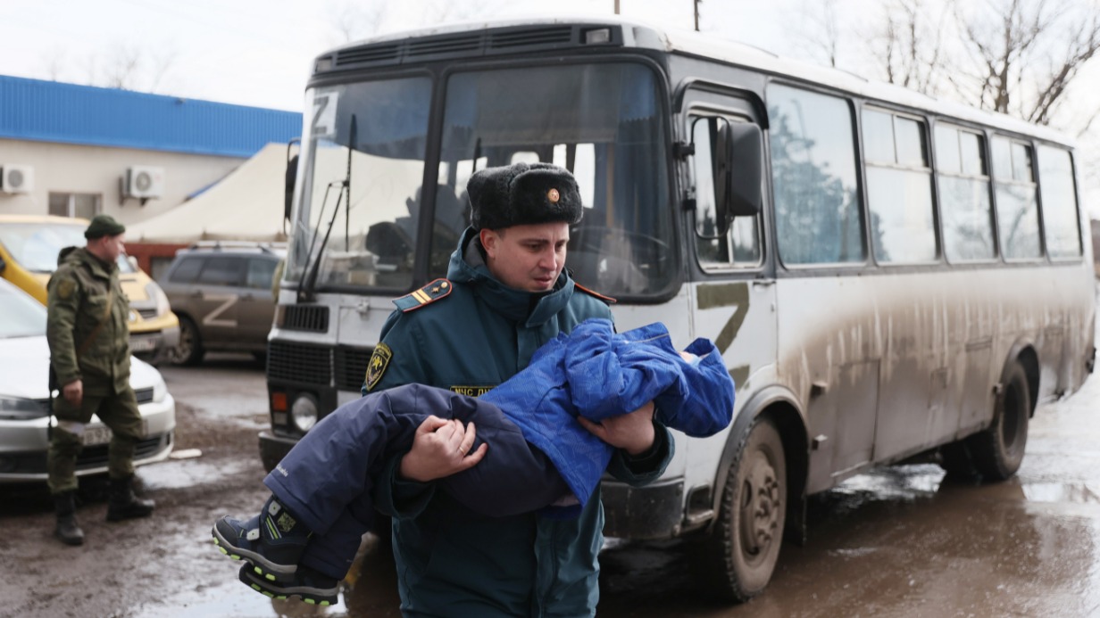 Село Безыменное. Сотрудник МЧС ДНР помогает перенести ребенка, самостоятельно эвакуировавшегося из Мариуполя, в пункт оказания помощи. Минобороны РФ сообщило об открытии гуманитарных коридоров. И они работают, несмотря на то что украинские власти пытаются утверждать обратное
