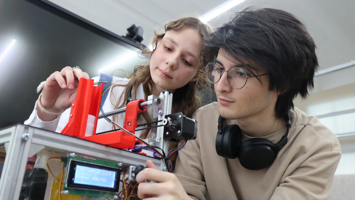 Учащиеся школы № 2065 Евгения Андреевская и Далгат Ибрагимов тестируют работу робота для изучения океанического ила